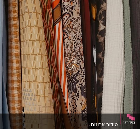 בגדים תלויים בארון עם דוגמאות שונות וצבעים מגוונים